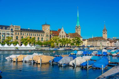 İsviçre 'de güneşli bir günde ünlü Fraumuenster Kilisesi ve Limmat nehri ile tarihi Zuerich şehir merkezinin panoramik manzarası.