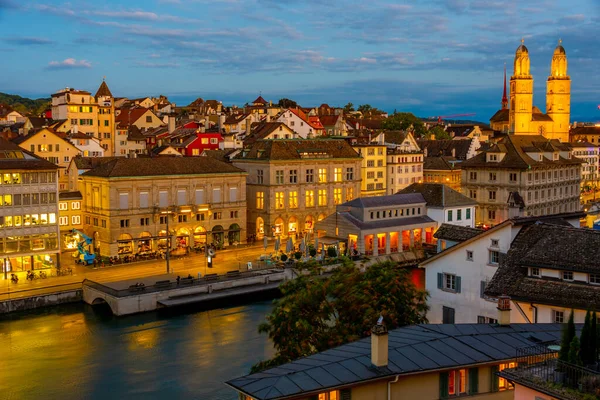 瑞士市政厅和Grossmuenster大教堂主导的Zuerich河堤码头日落 — 图库照片