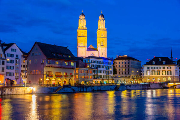 Sunset view of Limmat river with Grossmuenster cathedral in Zurich, Switzerland.