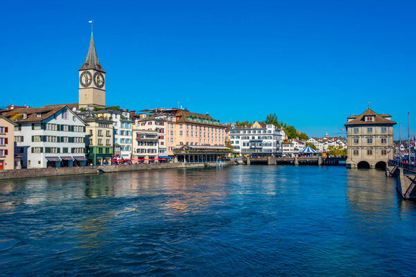 View of a quay of river Limmat in the Swiss city Zuerich with historical town hall.