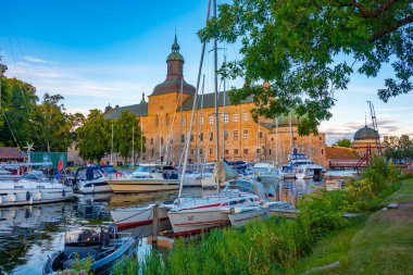 İsveç 'teki marina ve Vadstena kalesinin günbatımı manzarası.