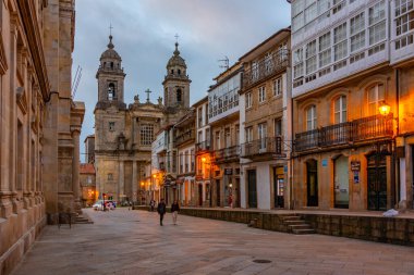 Santiago de Compostela, İspanya, 10 Haziran 2022: Santiago de Compostela, İspanya 'da dar bir caddenin sonundaki Saint Francis Kilisesi' nin günbatımı.
