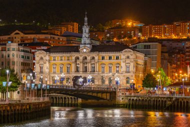 Bilbao, İspanya, 2 Haziran 2022: İspanya 'nın Bilbao kentindeki belediye binası yakınlarındaki Nervion nehrinin gece manzarası.