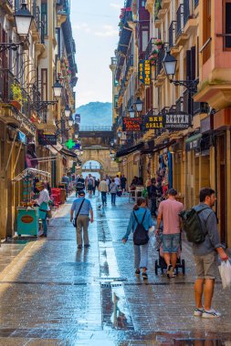 San Sebastian, İspanya, 2 Haziran 2022: İnsanlar eski San Sebastian, İspanya 'nın dar bir caddesinde geziniyorlar..
