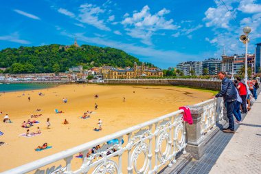 San Sebastian, İspanya, 2 Haziran 2022: İnsanlar İspanya 'nın San Sebastian kentindeki La Concha plajında güneşli bir günün tadını çıkarıyorlar..
