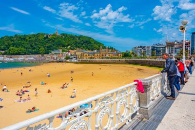 San Sebastian, Spain, June 2, 2022: People are enjoying a sunny day at La Concha beach at San Sebastian, Spain. clipart