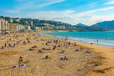 San Sebastian, İspanya, 1 Haziran 2022: İnsanlar İspanya 'nın San Sebastian kentindeki La Concha plajında güneşli bir günün tadını çıkarıyorlar..