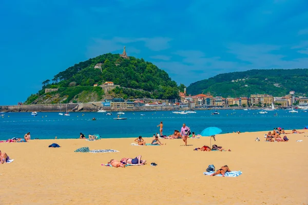 stock image San Sebastian, Spain, June 2, 2022: People are enjoying a sunny day at La Concha beach at San Sebastian, Spain.