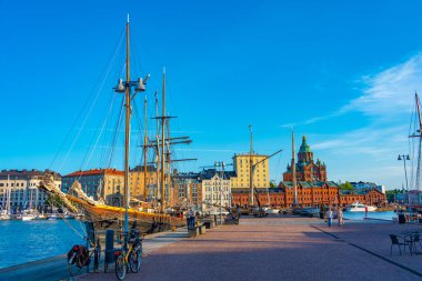 Helsinki, Finlandiya, 20 Temmuz 2022: Uspenski Katedrali, eski ticaret limanının kırmızı tuğlalı binalarının üzerinde yükseliyor. .