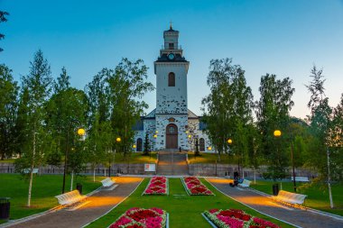 Kuopio, Finlandiya, 24 Temmuz 2022: Kuopio, Finlandiya 'daki Snellman Park' ın arkasındaki katedralin günbatımı.