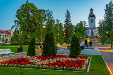 Kuopio, Finlandiya, 24 Temmuz 2022: Kuopio, Finlandiya 'daki Snellman Park' ın arkasındaki katedralin günbatımı.