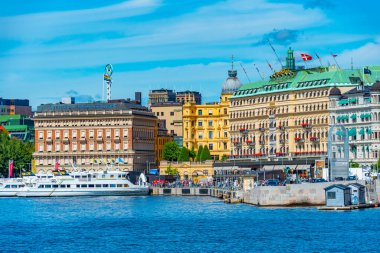 Stockholm, İsveç, 2 Ağustos 2022: Stockholm rıhtımı ve yanında İsveç 'te güzel eski evler.
