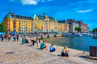 Stockholm, İsveç, 2 Ağustos 2022: Stockholm rıhtımı ve yanında İsveç 'te güzel eski evler.