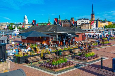 Stockholm, İsveç, 2 Ağustos 2022: Turistler Stockholm, İsveç 'teki Klara Malarstrand rıhtımında yolcu gemileri bekliyor.