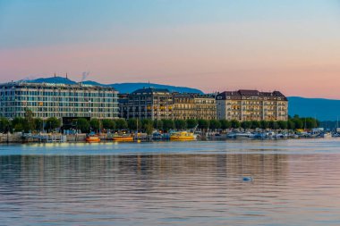 Cenevre, İsviçre, 19 Eylül 2022: İsviçre 'nin Cenevre kentinin göl kenarındaki bir gezinti alanının arkasındaki gündoğumu manzarası.