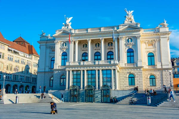 stock image Zuerich, Switzerland, September 21, 2022: People are passing by sechsenlautenplatz in the swiss city zurich which is dominated by majestic building of opera..