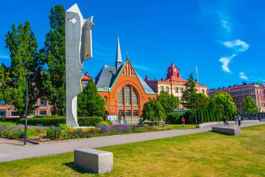Halmstad, İsveç, 12 Temmuz 2022: Picasso parkındaki bir kadın heykeli ve İsveç 'in Halmstad.IMAGE kasabasındaki Immanuel kilisesi.