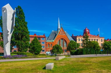 Halmstad, İsveç, 12 Temmuz 2022: Picasso parkındaki bir kadın heykeli ve İsveç 'in Halmstad.IMAGE kasabasındaki Immanuel kilisesi.