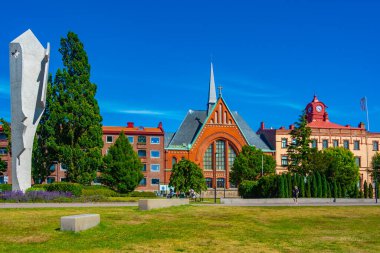 Halmstad, İsveç, 12 Temmuz 2022: Picasso parkındaki bir kadın heykeli ve İsveç 'in Halmstad.IMAGE kasabasındaki Immanuel kilisesi.