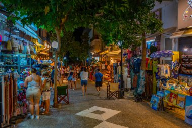 Agios Nikolaos, Yunanistan, 19 Ağustos 2022: Yunanistan 'ın Girit adasındaki Agios Nikolaos kasabasında turistik bir sokakta gezinen insanların günbatımı.