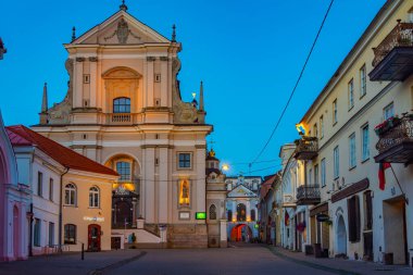 Vilnius, Litvanya, 7 Temmuz 2022: Litvanya 'nın Vilnius kentindeki St. Theresa Kilisesi' ne doğru giden bir caddenin gece görüşü..