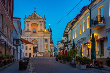 Vilnius, Litvanya, 7 Temmuz 2022: Litvanya 'nın Vilnius kentindeki St. Theresa Kilisesi' ne doğru giden bir caddenin gece görüşü..