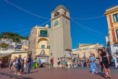 Capri, İtalya, 20 Mayıs 2022: İnsanlar Capri, İtalya 'daki Saint Stefano kilisesi önünde güneşli bir günün tadını çıkarıyorlar.
