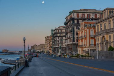 Napoli, İtalya, 19 Mayıs 2022: İtalya 'nın Napoli kentindeki deniz kenarındaki gezinti alanının gün batımı manzarası.