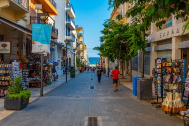 Heraklion, Yunanistan, 18 Ağustos 2022: Girit adasındaki Heraklion limanındaki bir turizm caddesinde insanlar geziniyor.