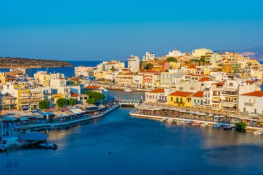 Agios Nikolaos, Yunanistan, 19 Ağustos 2022: Voulismeni gölü ve Yunan kenti Agios Nikolaos 'un Girit adasındaki günbatımı manzarası.