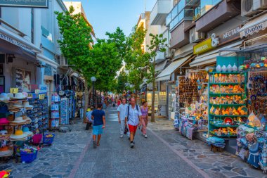 Agios Nikolaos, Yunanistan, 19 Ağustos 2022: Yunanistan 'ın Girit adasındaki Agios Nikolaos kasabasında turistik bir sokakta gezinen insanların günbatımı.