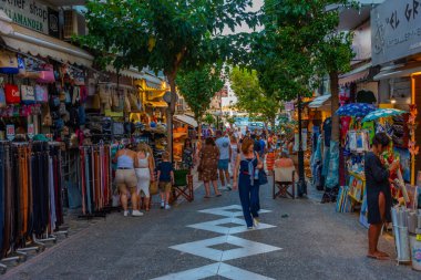 Agios Nikolaos, Yunanistan, 19 Ağustos 2022: Yunanistan 'ın Girit adasındaki Agios Nikolaos kasabasında turistik bir sokakta gezinen insanların günbatımı.