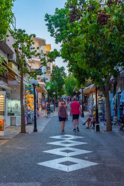 Agios Nikolaos, Yunanistan, 19 Ağustos 2022: Yunanistan 'ın Girit adasındaki Agios Nikolaos kasabasında turistik bir sokakta gezinen insanların günbatımı.