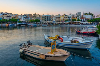 Agios Nikolaos, Yunanistan, 19 Ağustos 2022: Voulismeni gölü ve Yunan kenti Agios Nikolaos 'un Girit adasındaki günbatımı manzarası.