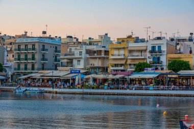 Agios Nikolaos, Yunanistan, 19 Ağustos 2022: Voulismeni gölü ve Yunan kenti Agios Nikolaos 'un Girit adasındaki günbatımı manzarası.