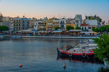 Agios Nikolaos, Yunanistan, 19 Ağustos 2022: Voulismeni gölü ve Yunan kenti Agios Nikolaos 'un Girit adasındaki günbatımı manzarası.