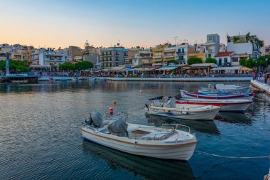 Agios Nikolaos, Yunanistan, 19 Ağustos 2022: Voulismeni gölü ve Yunan kenti Agios Nikolaos 'un Girit adasındaki günbatımı manzarası.