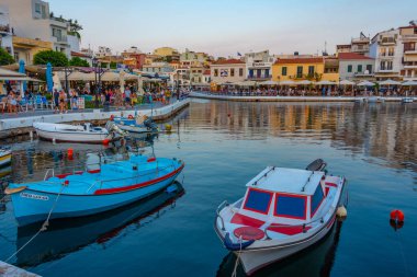 Agios Nikolaos, Yunanistan, 19 Ağustos 2022: Voulismeni gölü ve Yunan kenti Agios Nikolaos 'un Girit adasındaki günbatımı manzarası.
