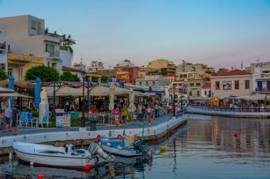 Agios Nikolaos, Yunanistan, 19 Ağustos 2022: Voulismeni gölü ve Yunan kenti Agios Nikolaos 'un Girit adasındaki günbatımı manzarası.