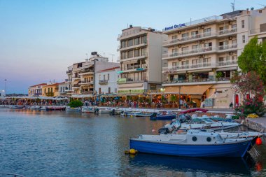 Agios Nikolaos, Yunanistan, 19 Ağustos 2022: Voulismeni gölü ve Yunan kenti Agios Nikolaos 'un Girit adasındaki günbatımı manzarası.