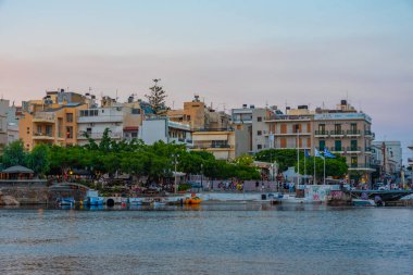 Agios Nikolaos, Yunanistan, 19 Ağustos 2022: Voulismeni gölü ve Yunan kenti Agios Nikolaos 'un Girit adasındaki günbatımı manzarası.