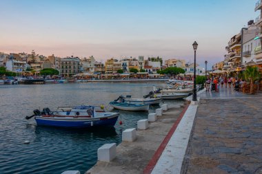 Agios Nikolaos, Yunanistan, 19 Ağustos 2022: Voulismeni gölü ve Yunan kenti Agios Nikolaos 'un Girit adasındaki günbatımı manzarası.