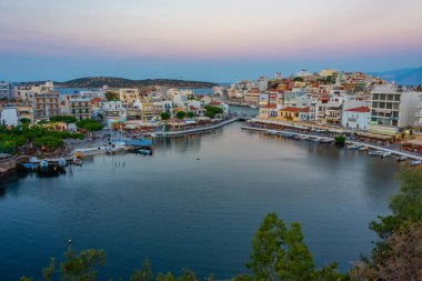 Agios Nikolaos, Yunanistan, 19 Ağustos 2022: Voulismeni gölü ve Yunan kenti Agios Nikolaos 'un Girit adasındaki günbatımı manzarası.