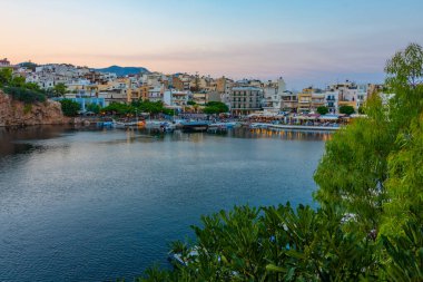 Agios Nikolaos, Yunanistan, 19 Ağustos 2022: Voulismeni gölü ve Yunan kenti Agios Nikolaos 'un Girit adasındaki günbatımı manzarası.