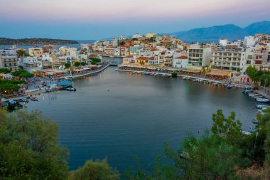 Agios Nikolaos, Yunanistan, 19 Ağustos 2022: Voulismeni gölü ve Yunan kenti Agios Nikolaos 'un Girit adasındaki günbatımı manzarası.