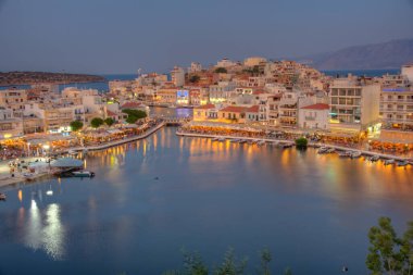 Agios Nikolaos, Yunanistan, 19 Ağustos 2022: Girit adasındaki Voulismeni gölü ve Yunan kenti Agios Nikolaos 'un gece manzarası.