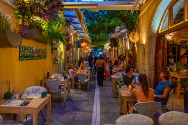 Rethimno, Yunanistan, 20 Ağustos 2022: Yunanistan 'ın Girit adasındaki Rethimno kentindeki bir turizm caddesinde gün batımı manzarası.