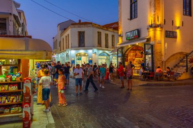 Rethimno, Yunanistan, 20 Ağustos 2022: Yunanistan 'ın Girit adasındaki Rethimno kentindeki bir turizm caddesinde gün batımı manzarası.