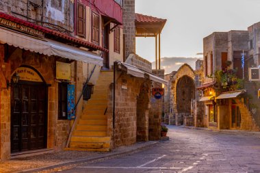 Rodos, Yunanistan, 25 Ağustos 2022: Yunan kenti Rodos 'ta bir turist sokağının gün doğumu manzarası.
