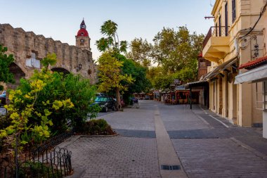 Rodos, Yunanistan, 25 Ağustos 2022: Yunan kenti Rodos 'ta bir turist sokağının gün doğumu manzarası.